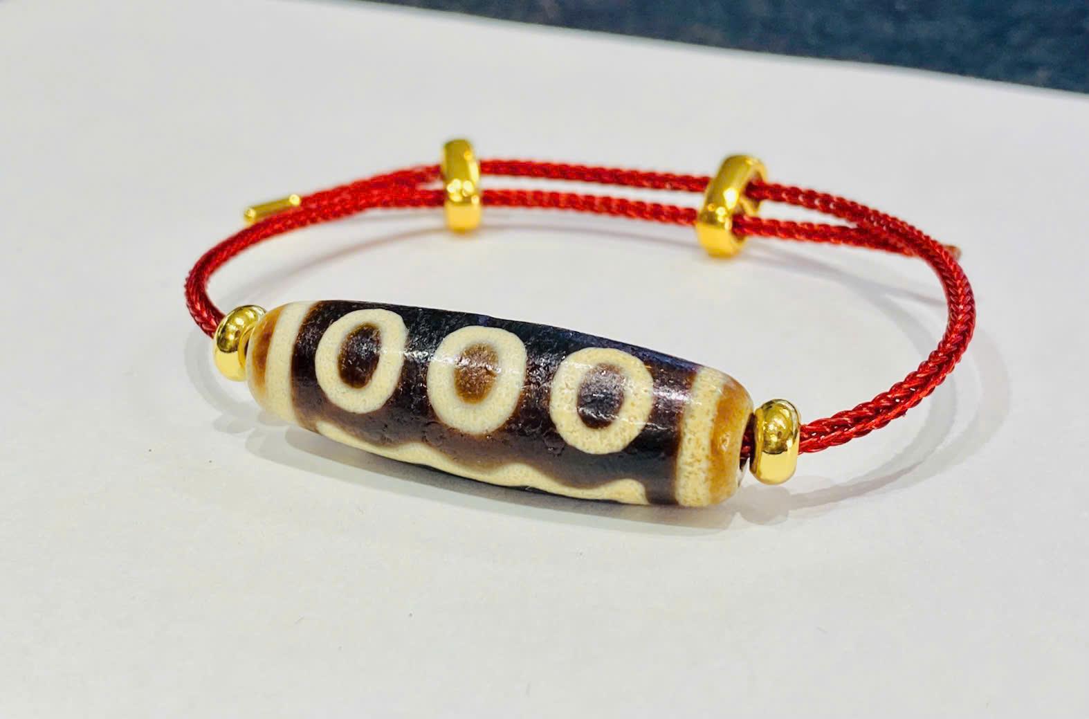 z7328718703213_b2ff2f20fe0e0f2b3b3a6529e04fec10 Vòng tay lên dây cáp Cụ Dzi 5 mắt thân nâu lên vảy