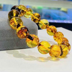 Hổ phách Amber sở hữu gam màu vàng rất đặc trưng, không rực gắt mà dịu, sâu và có độ chuyển màu tự nhiên. Trong cùng một chiếc vòng, có thể thấy sự hòa quyện tinh tế giữa những viên vàng trong như mật ong chín, những viên ngả vàng nâu trầm mang nét cổ điển, sang trọng, xen kẽ là các viên ánh cam nhẹ tạo cảm giác tươi mới và ấm áp, tất cả kết hợp lại tạo nên một tổng thể hài hòa, sống động và đậm dấu ấn thời gian của hổ phách tự nhiên.